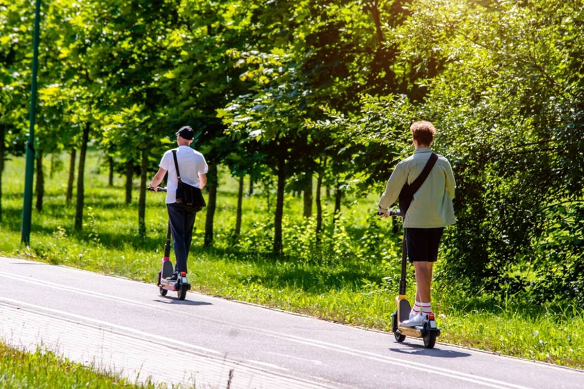 Paspirtukų vairuotojai važiuoja dviračių taku pavasarį